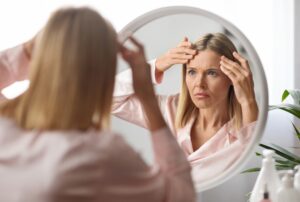 woman who did stop getting Botox examining wrinkles