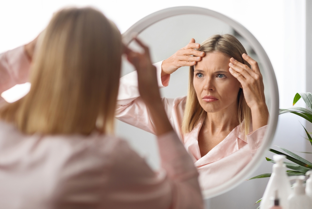 woman who did stop getting Botox examining wrinkles